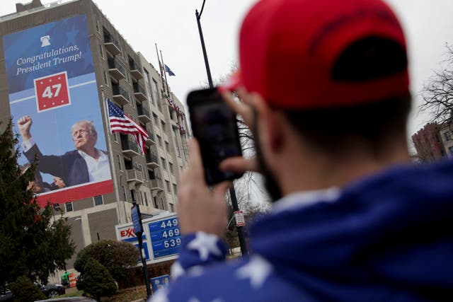 <p>A person takes a picture of a U.S. President-elect Donald Trump 's poster outside the Heritage Foundation as his supporters gather for a rally a day before he is scheduled to be inaugurated for a second term, in Washington, U.S., January 19, 2025</p>