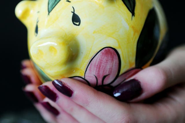 <p>A woman holding a piggy bank </p>