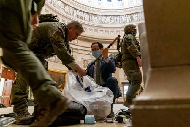 <p>Andy Kim, then a congressman and now a senator, helps ATF officers clean up the damage done in the Capitol on January 6, 2021 </p>