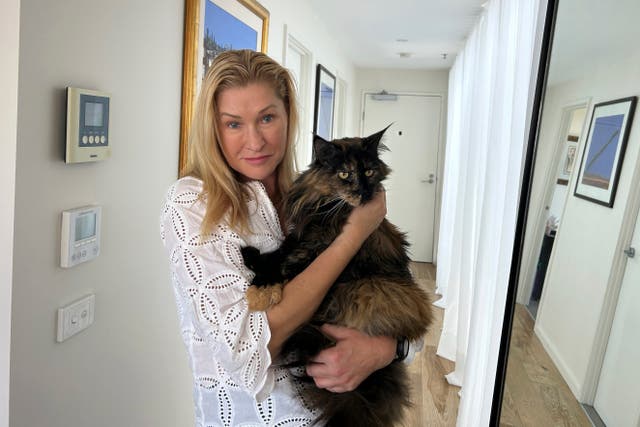<p>Margo Neas holds her cat Mittens at her home in Melbourne</p>