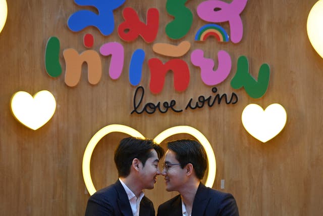 <p>A couple poses for pictures at a marriage registration event at Paragon shopping mall in Bangkok on 23 January 2025. A high-profile gay couple married in Thailand on 23 January as the kingdom’s same-sex marriage law went into effect, an AFP journalist saw, among the first of hundreds expected to do so</p>