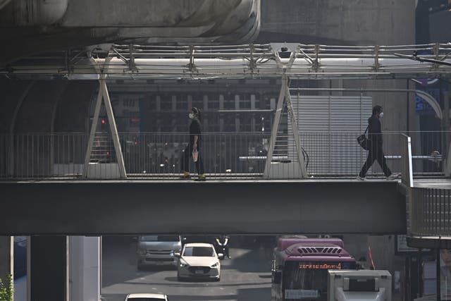 <p>People in face masks in Bangkok </p>