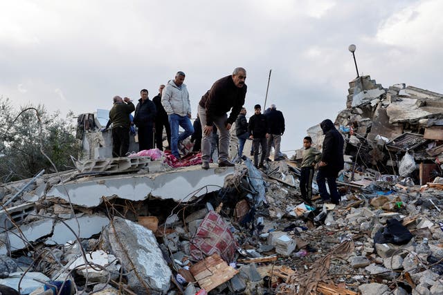 <p>Palestinians gather near damaged property after two Palestinian gunmen were killed in an Israeli raid</p>
