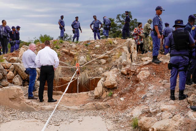 <p> Police officers and private security personnel stand by the opening of a reformed gold mineshaft</p>
